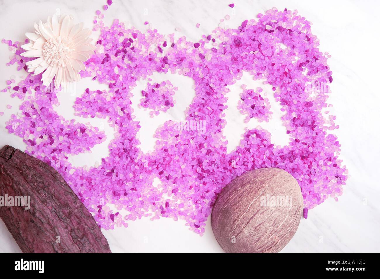Spa word of the bath salt on the marble table with coconut and cacao bean. Spa salon backgrounds and templates Stock Photo
