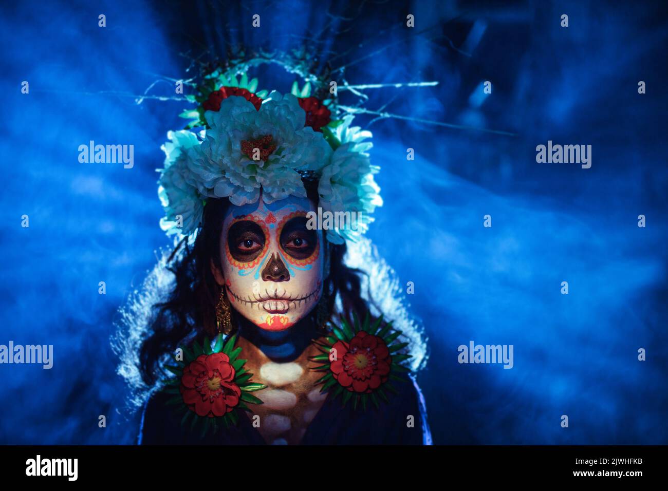 Woman with mexican skull halloween makeup on face. Day of the dead aka Dia de los Muertos and halloween party concept. Stock Photo