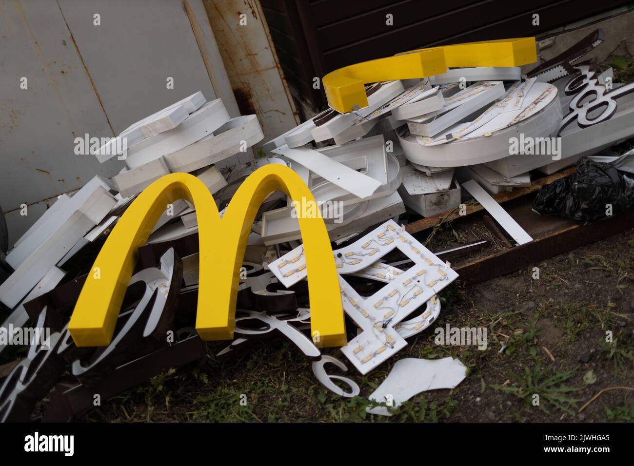 Moscow, Russia - 06.21.2022: McDonalds logo letter character M on dirty rubbish heap dump trash litter garbage. Fast food and sanctions concept. Environment issues Stock Photo