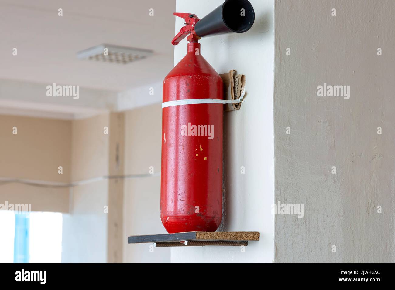 Portable handheld fire extinguisher mounted on the wall inside the room Stock Photo Alamy