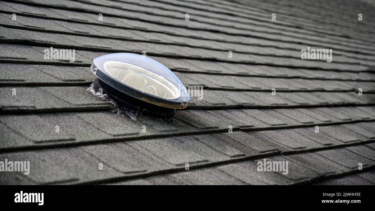 Dome shaped solar tube skylight on asphalt shingle roof Stock Photo Alamy