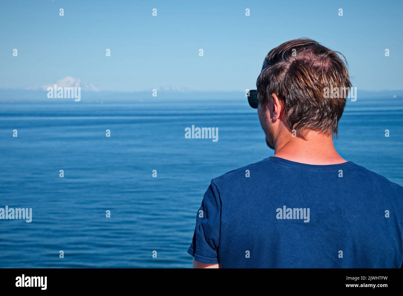 Mature man standing on the deck of the ferry Stock Photo