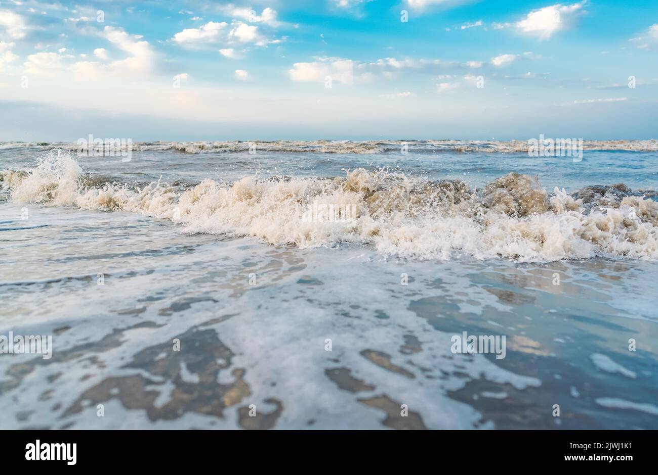 Waves on beach and blue sky with clouds landscape Stock Photo - Alamy
