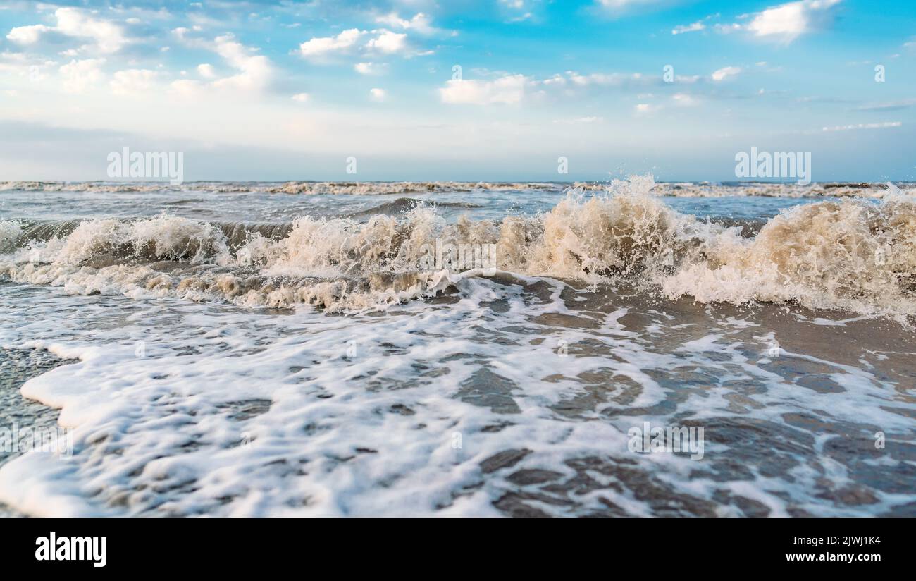 Waves on beach and blue sky with clouds landscape Stock Photo - Alamy