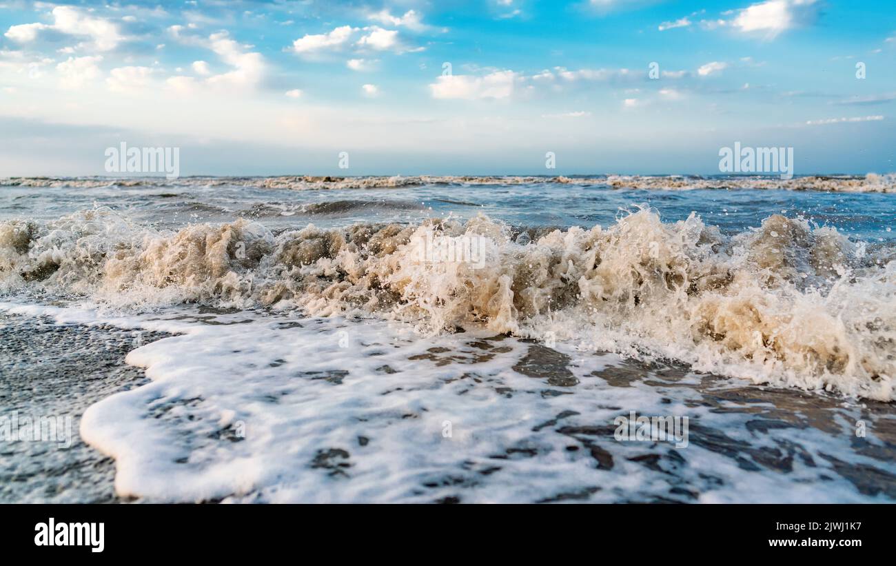 Waves on beach and blue sky with clouds landscape Stock Photo - Alamy