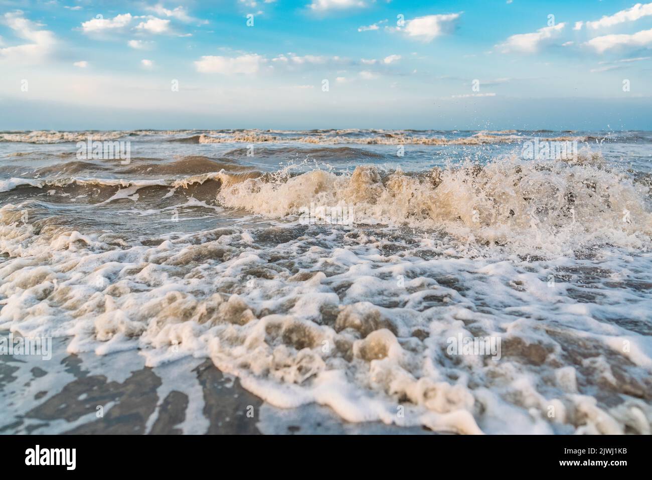 Waves on beach and blue sky with clouds landscape Stock Photo - Alamy