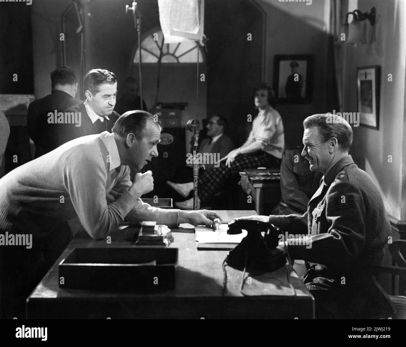 Cinematographer ARTHUR IBBETSON Director RONALD NEAME and JOHN MILLS on set candid with Movie Crew during filming of TUNES OF GLORY 1960 director RONALD NEAME novel / screenplay James Kennaway music Malcolm Arnold Knightsbridge Films / United Artists Stock Photo