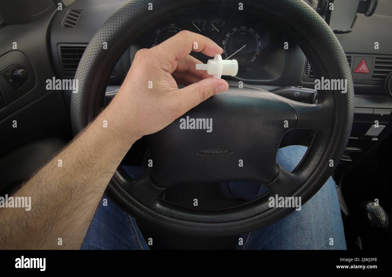 Driver holds breathalyzer mouthpiece sitting in the car. Point of view shot Stock Photo