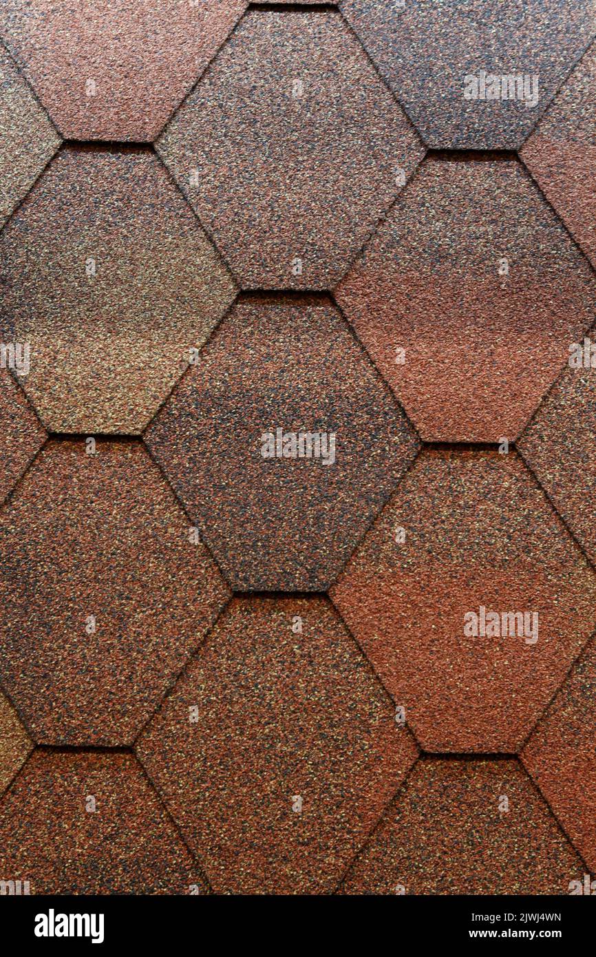 A closeup of asphalt roofing shingles of a diamond shape, and a