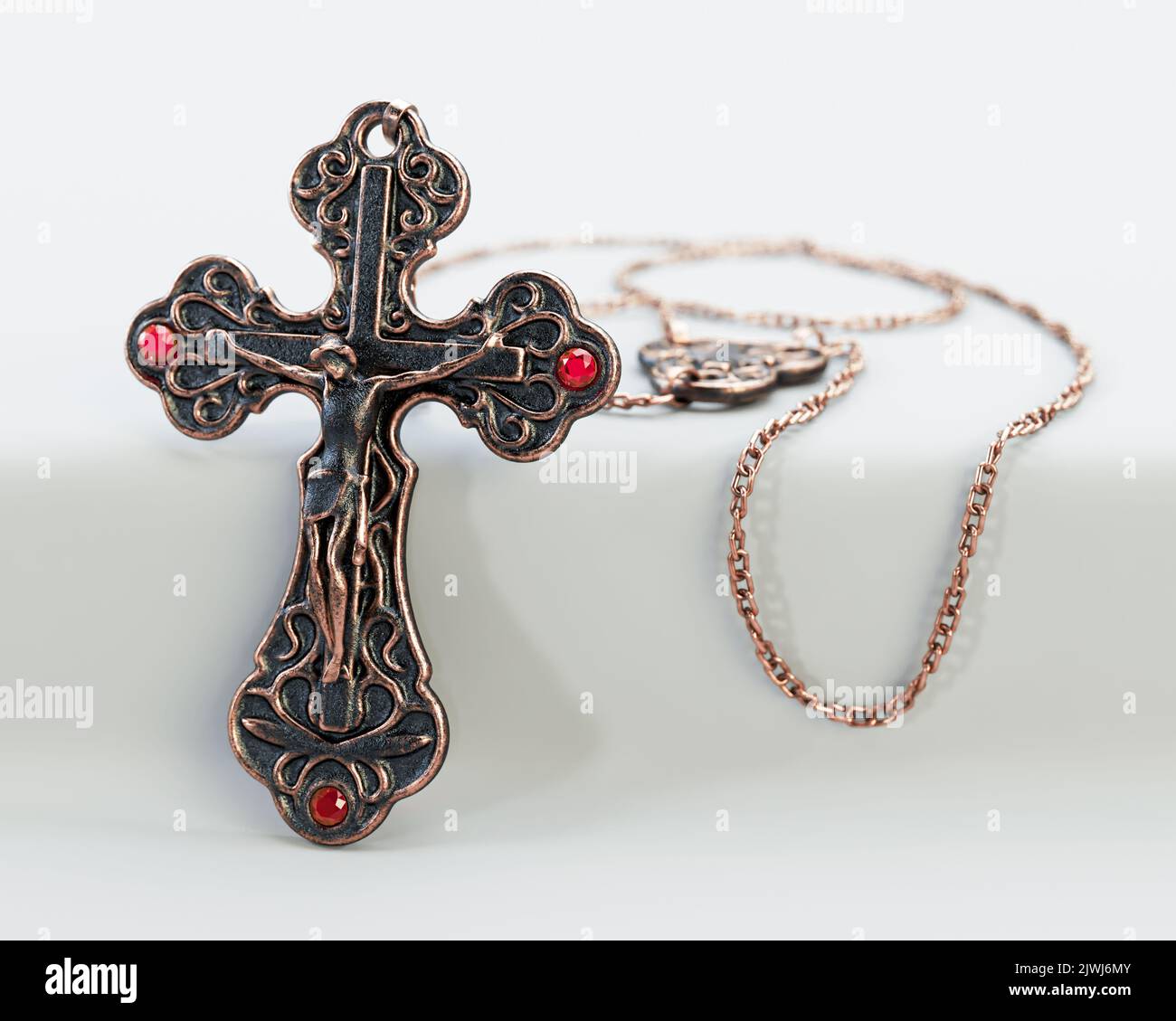 A closeup of an ornate brass antique rosary chain necklace with a crucifix draped on an isolated white background - 3D render Stock Photo