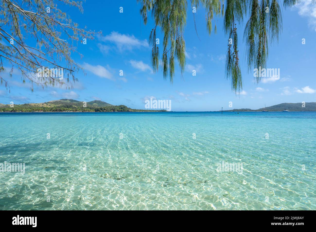 Blue Lagoon at Nanuya Island with Matacawa Levu Island in the distance. Yasawa Island, Fiji Stock Photo