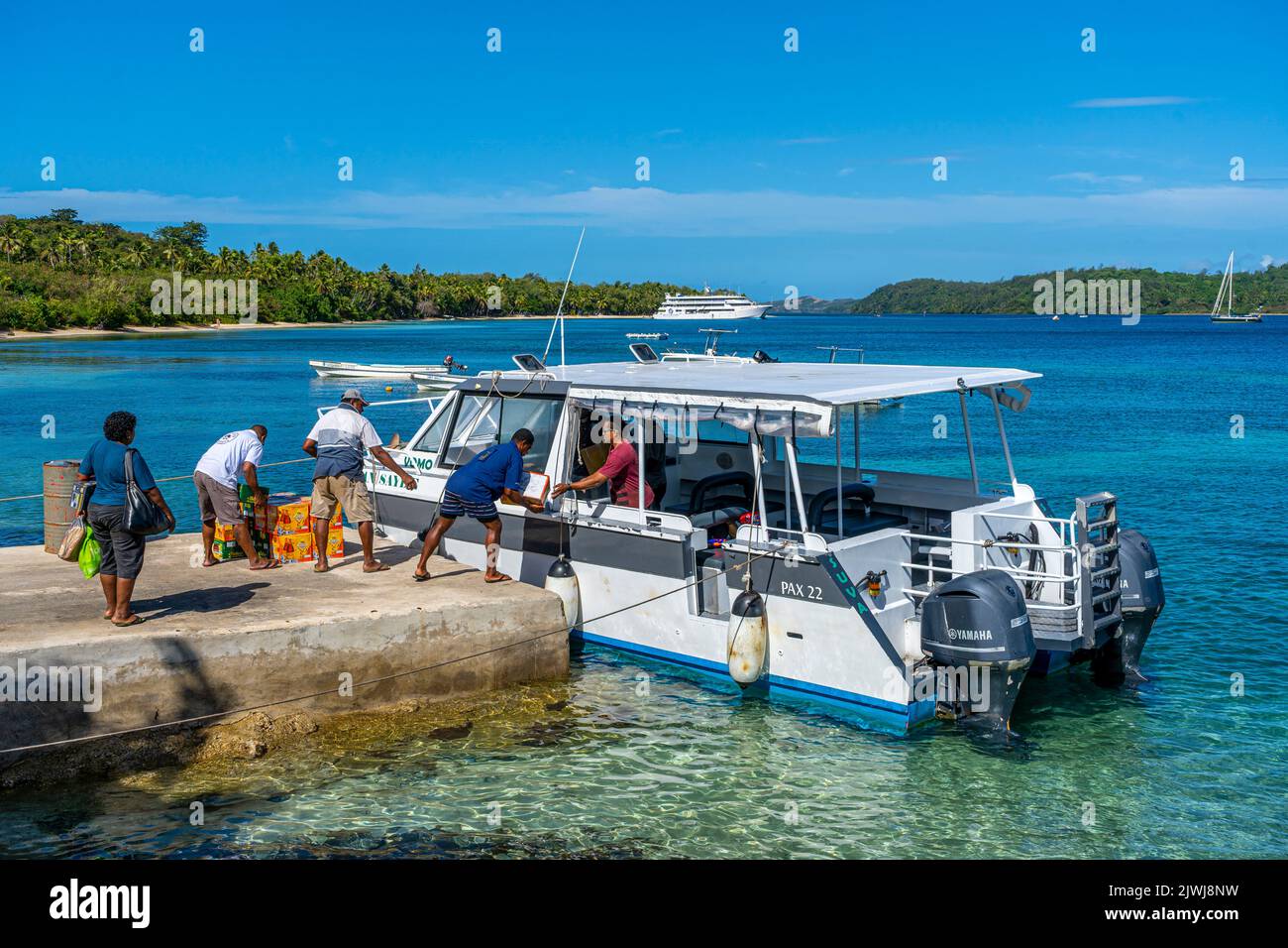 Inter-island taxi offloading supplies on wharf at Nanuya Island, Yasawa Group, Fiji Stock Photo