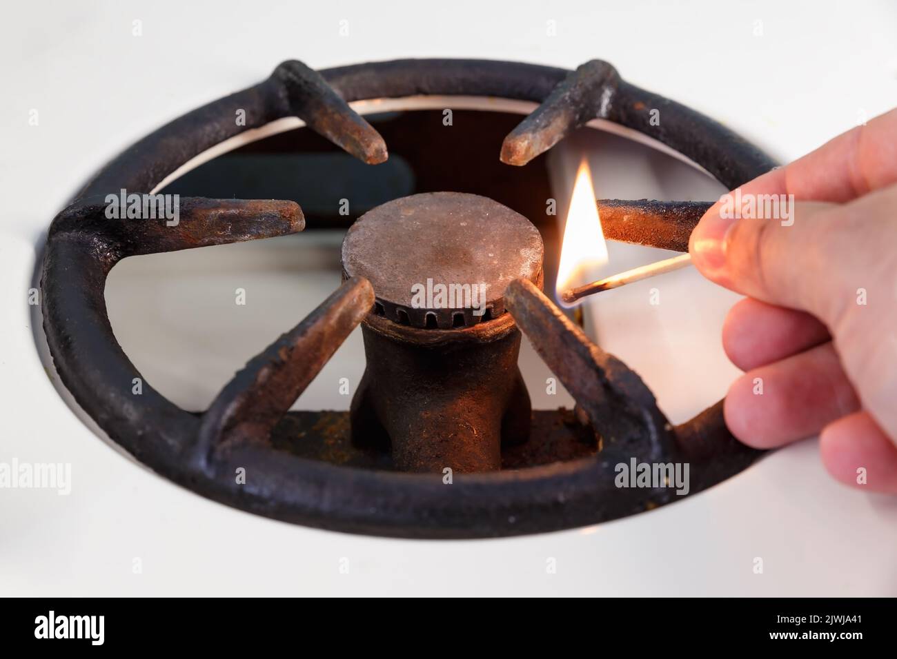 A man lights a gas stove with a match. vintage gas burner without flame