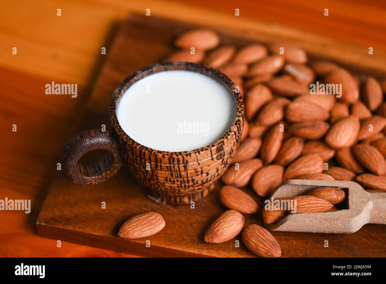 Almond milk and Almonds nuts on wooden background, Delicious sweet almonds on the table, roasted almond nut for healthy food and snack Stock Photo