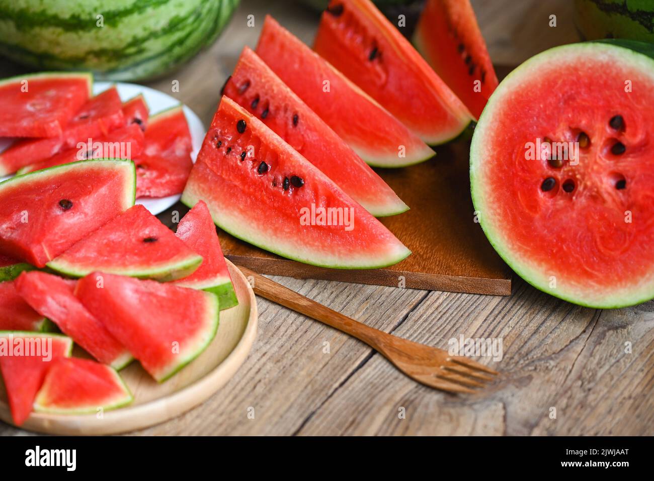 Watermelon slice and cut half on wooden background, Closeup sweet watermelon slices pieces fresh watermelon tropical summer fruit Stock Photo