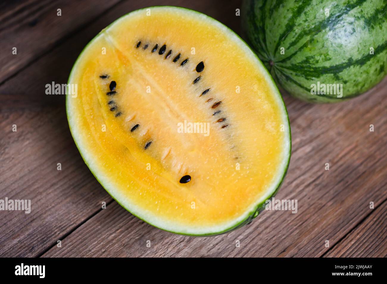 Yellow watermelon cut half on wooden, Closeup pile of sweet watermelon slices pieces fresh watermelon tropical summer fruit Stock Photo