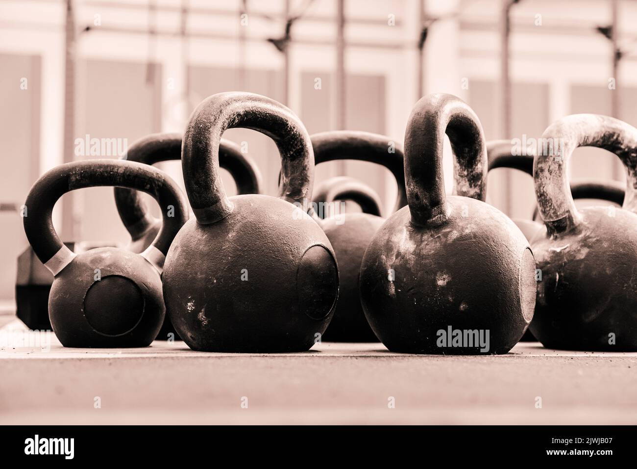 Ground level of many heavy kettlebells for functional workout placed on floor in light gym Stock Photo
