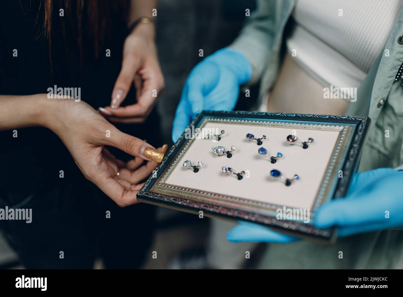 Young woman doing ear piercing at beauty studio salon Stock Photo Alamy