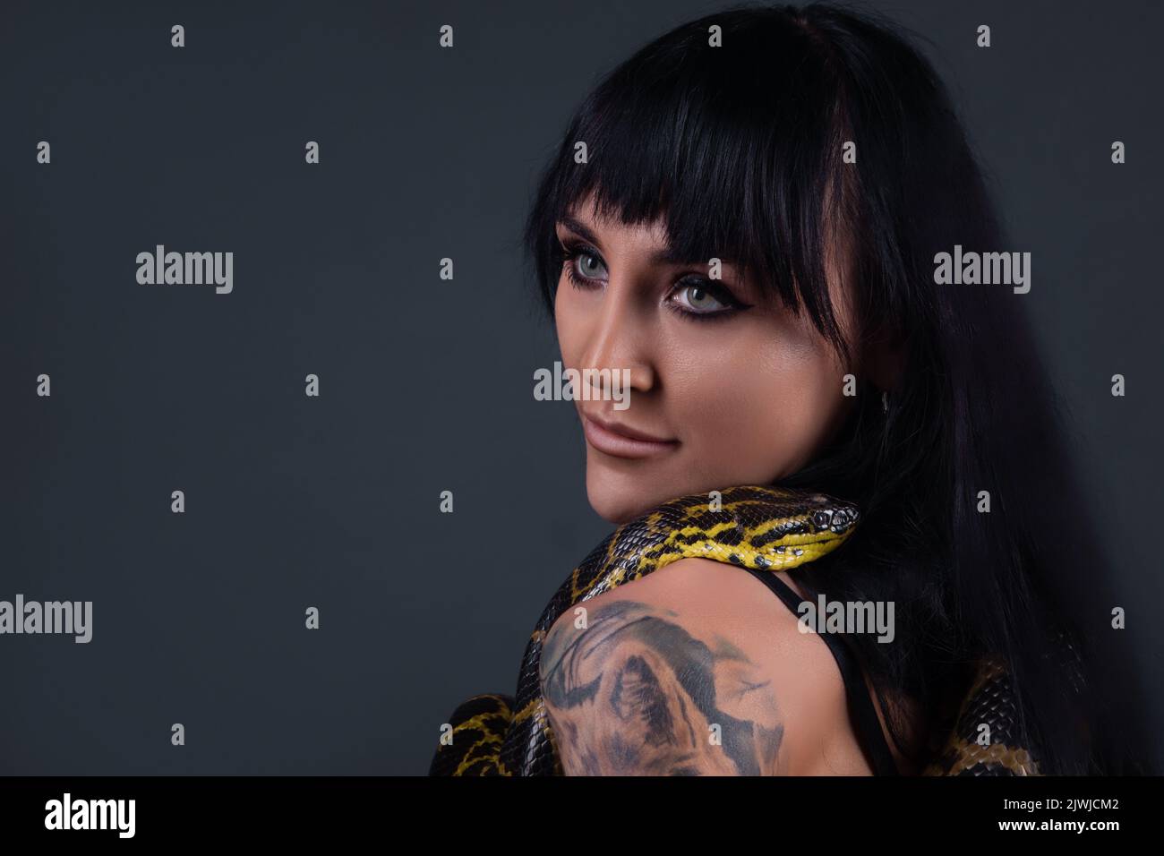 Image of the woman with yellow anaconda on shoulders and neck Stock Photo