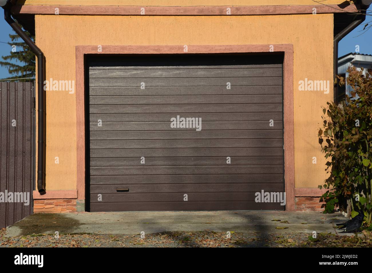 A closeup of a detached car garage with rolling automatic garage door