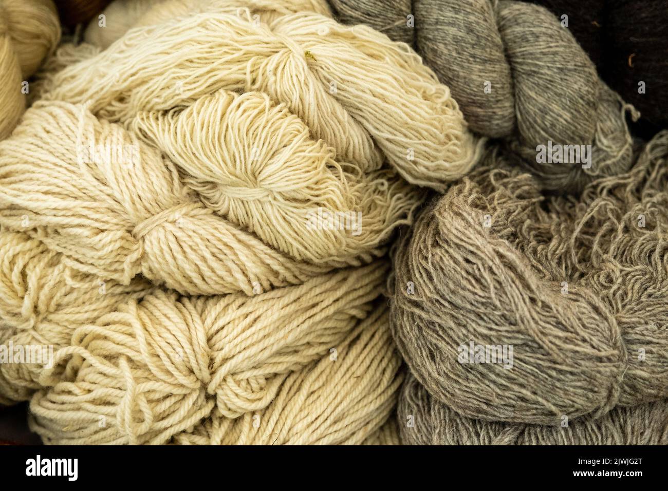 Close-up of sheep's wool threads in white and pale colors handmade Stock Photo