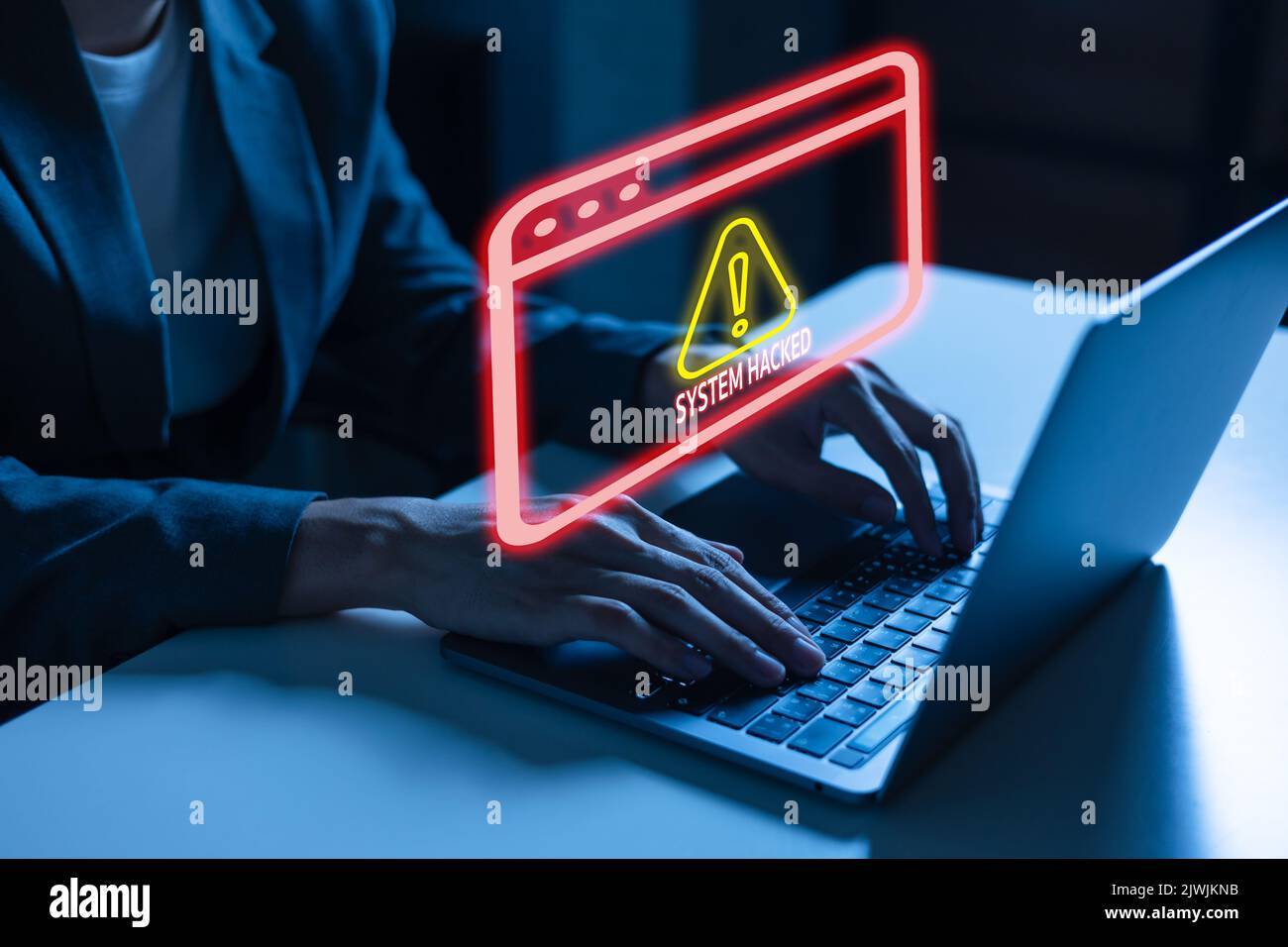Young man in business suit using a laptop computer facing a cyber attack warning and box of error messages for being hacked and compromised from the hackers Stock Photo