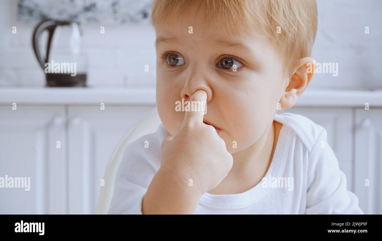 close up of naughty toddler boy picking his nose and looking away Stock Photo