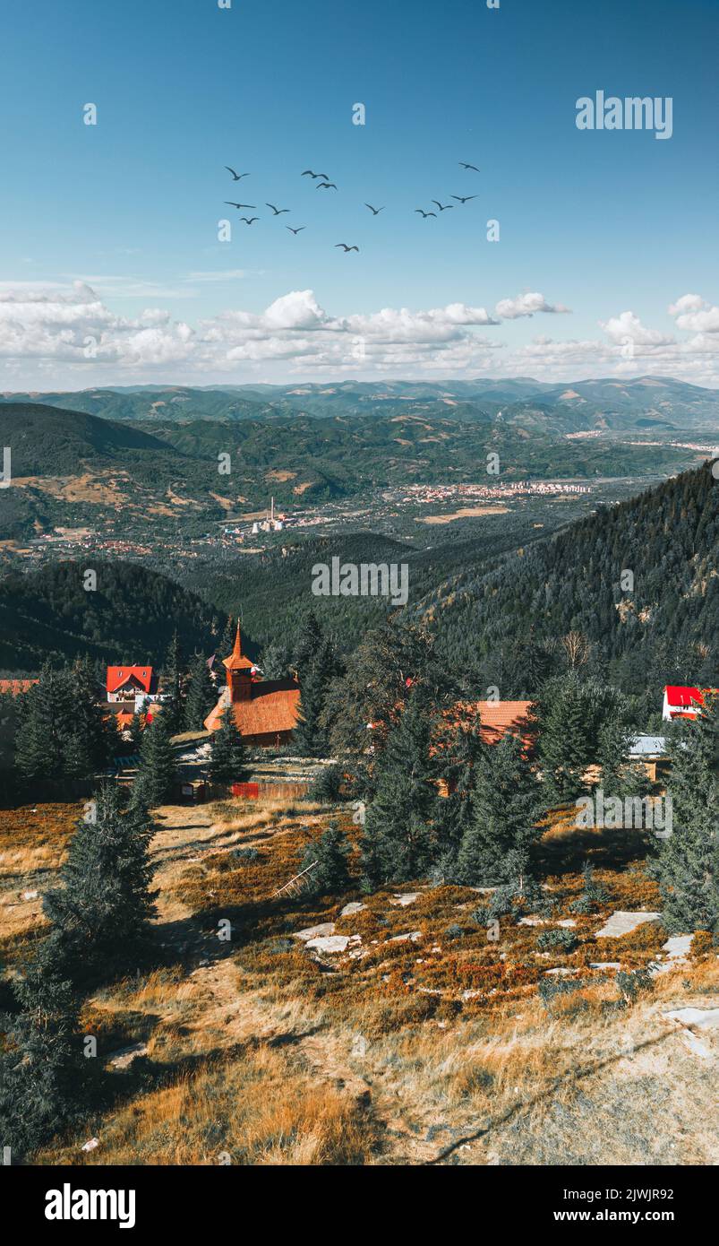 Aerial view over Carpathian mountains and church on a summer day. Straja ski resort viewed in summer Stock Photo