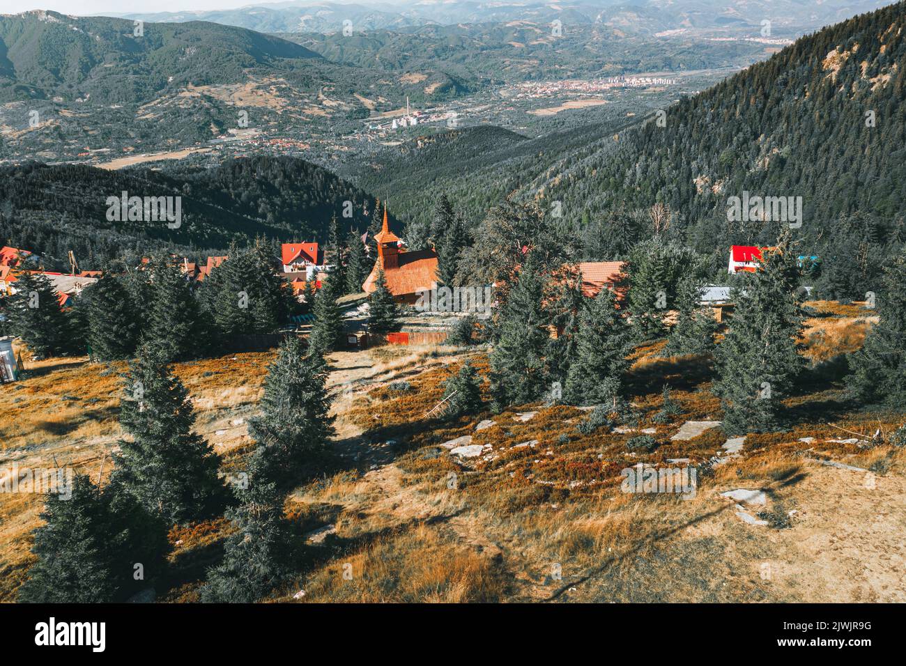 Aerial view over Carpathian mountains and church on a summer day. Straja ski resort viewed in summer Stock Photo