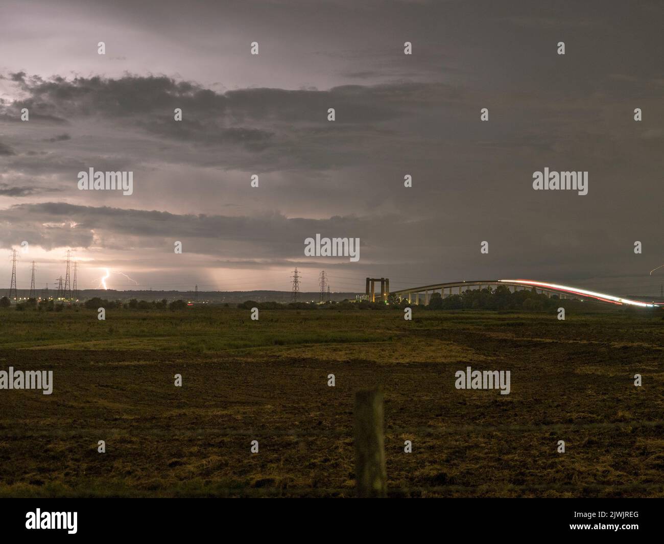 Minster on Sea, Kent, UK.  6th September, 2022. UK Weather: lightning seen near the Kingsferry Bridge and Sheppey Crossing during a thunderstorm from Minster on Sea, Kent. Credit: James Bell/Alamy Live News Stock Photo
