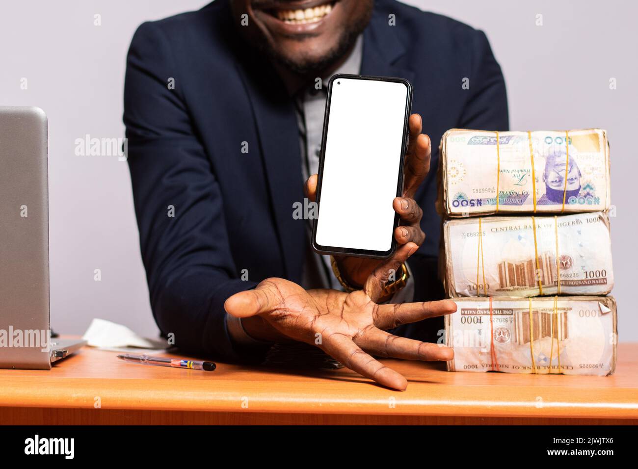 excited black man shows his phone screen next to a lot of money Stock ...