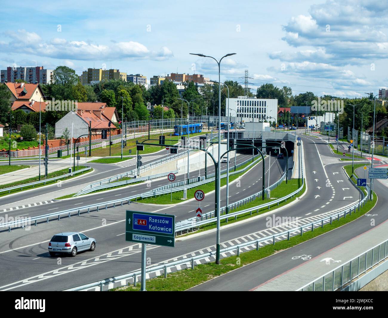 New city highway in Krakow, Poland, called Trasa Łagiewnicka with tunnels, tramway and multilevel crossroads. Slip roads and special pavements for bic Stock Photo