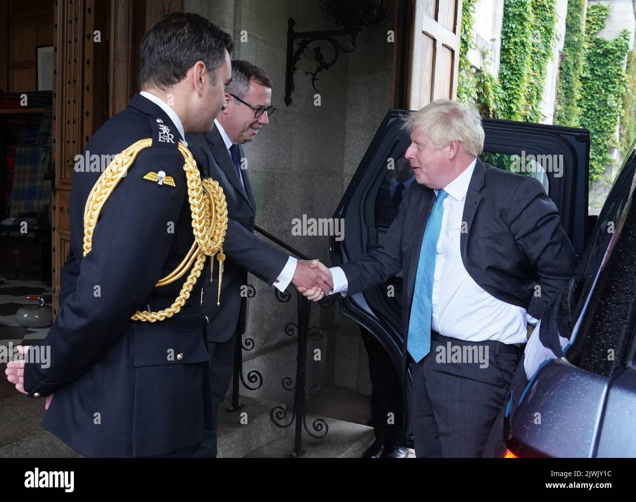 Outgoing Prime Minister Boris Johnson is greeted by the Queen Elizabeth II's Equerry Lieutenant Colonel Tom White and her private Secretary Sir Edward Young as he arrives at Balmoral for an audience to formally resign as Prime Minister. Picture date: Tuesday September 6, 2022. Stock Photo