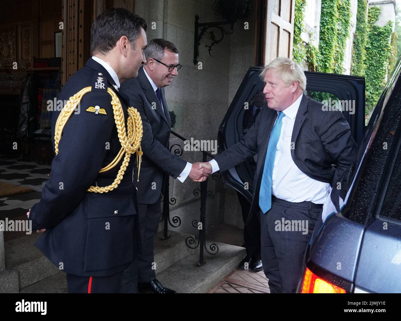 Outgoing Prime Minister Boris Johnson is greeted by the Queen Elizabeth II's Equerry Lieutenant Colonel Tom White and her private Secretary Sir Edward Young as he arrives at Balmoral for an audience to formally resign as Prime Minister. Picture date: Tuesday September 6, 2022. Stock Photo