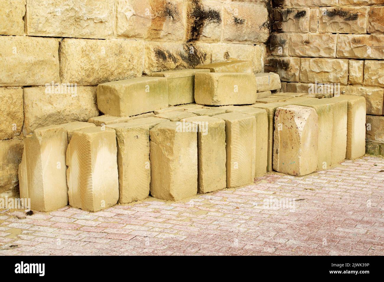 Pile of sandstone being stored against a wall  blocks ready for use Stock Photo