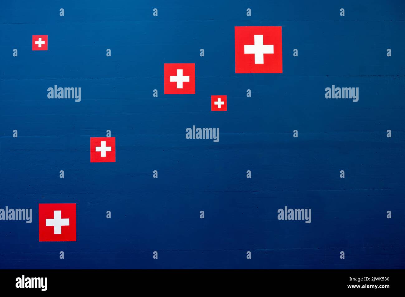 Swiss flag icon on blue wall. Abstract backgrounds. Copy space. Stock Photo