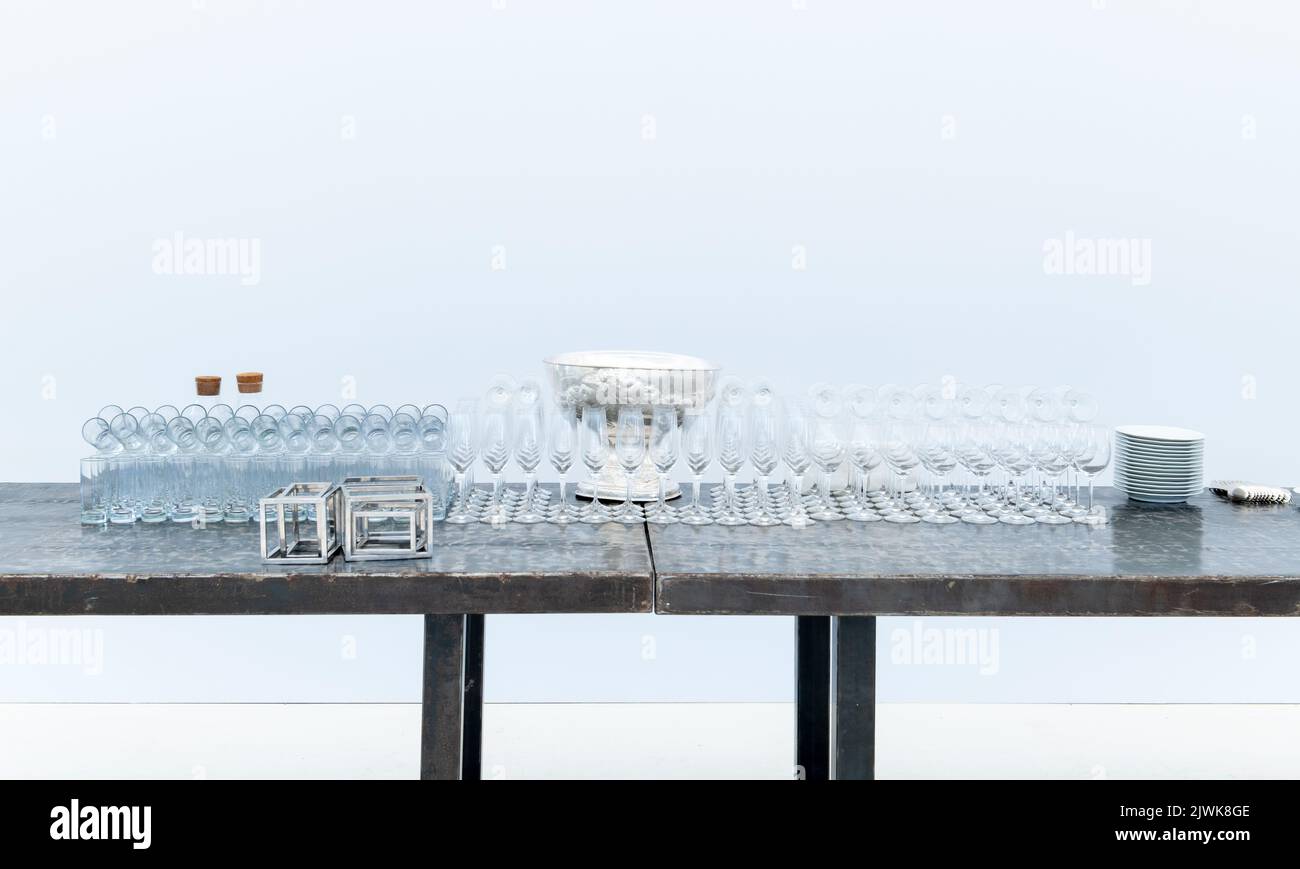 Empty glassware setting on table, glasses aligned ready for party, event, meeting, front view white background Stock Photo