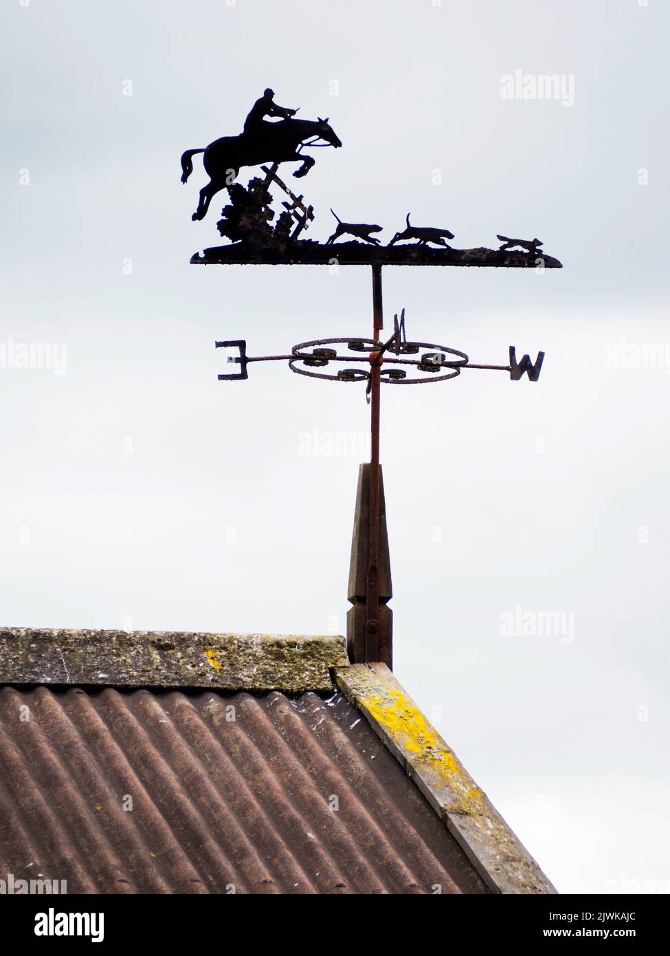 Hunting scene weather vane atop the barn. Horse & rider with 3 hounds. Stock Photo