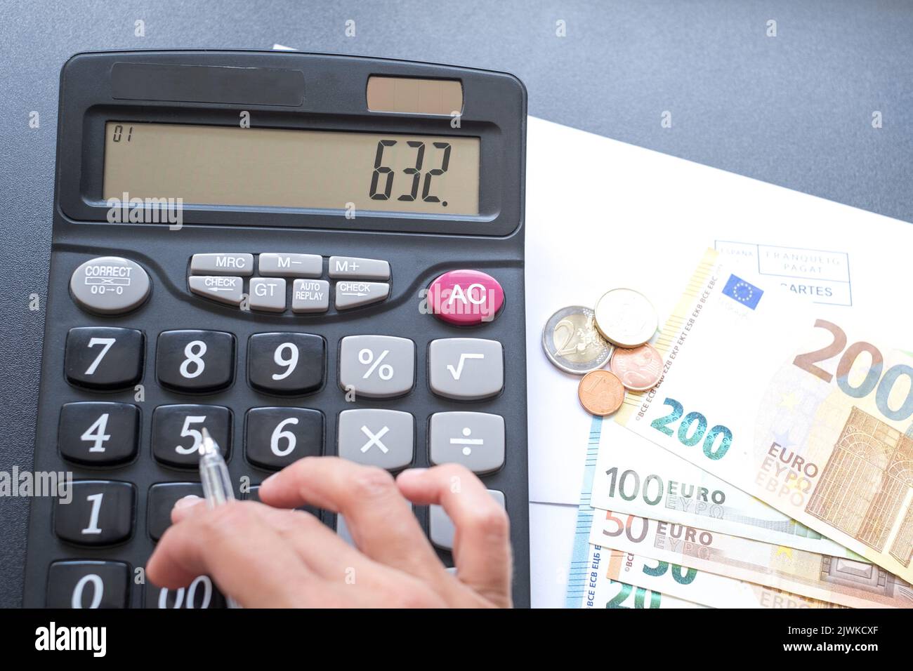 Calculator, money, pen and envelope on the table. Counting money