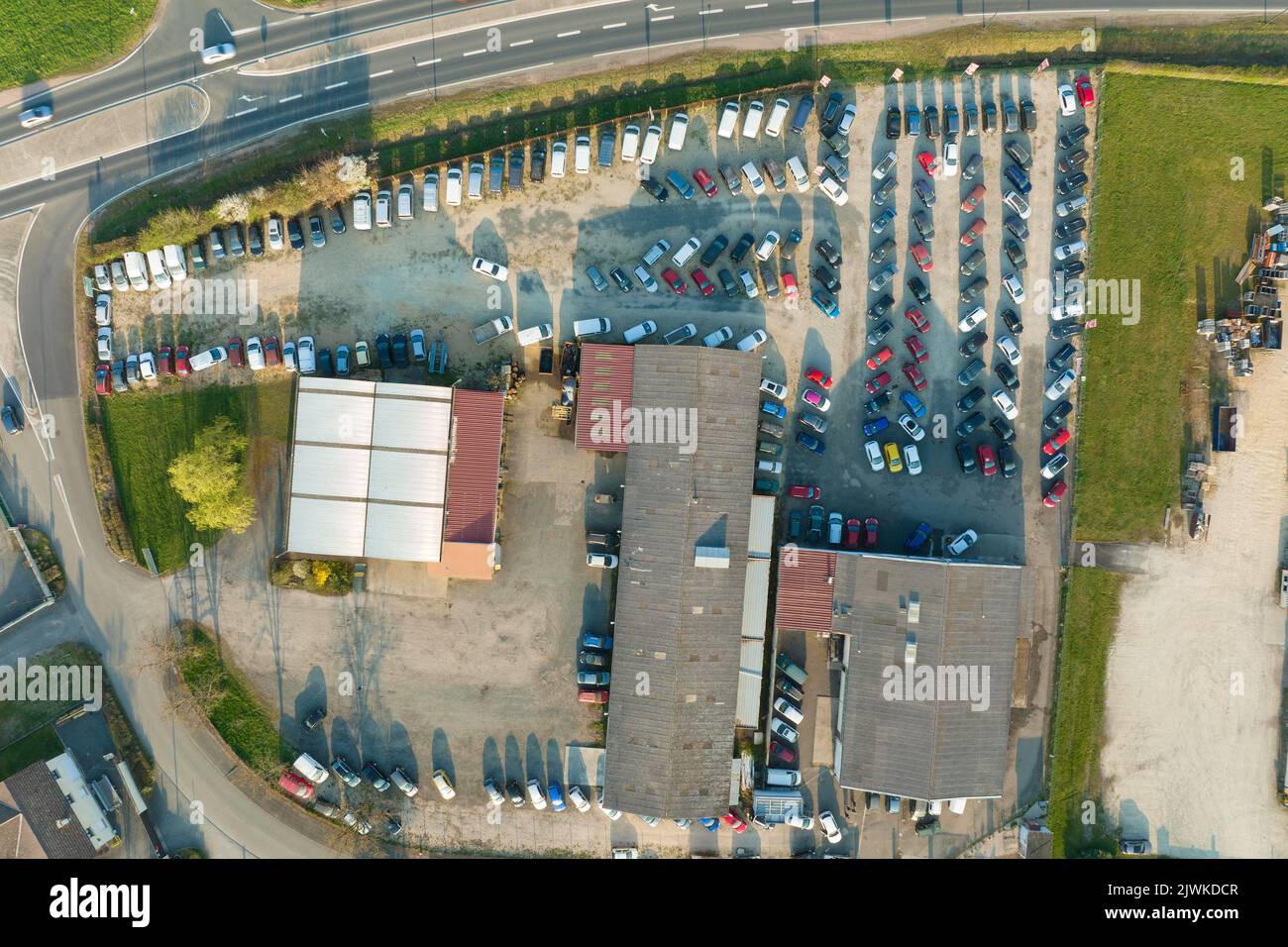 Aerial view of many colorful cars parked on dealer parking lot for sale
