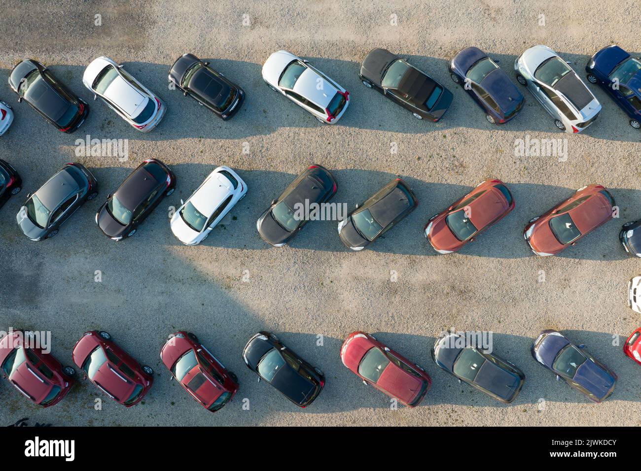 Aerial view of many colorful cars parked on dealer parking lot for sale