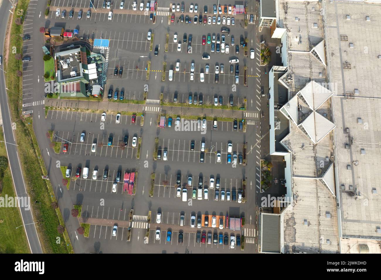 Aerial view of many colorful cars parked on parking lot with lines and