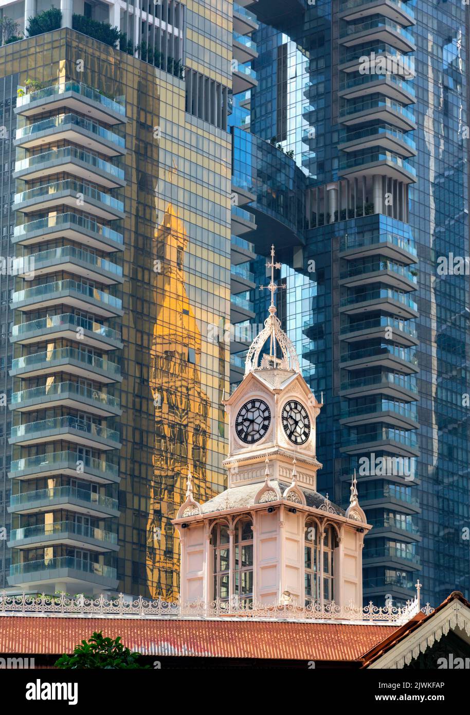 Clock tower of the 19th century Lau Pa Sat, also known as Telok Ayer Market against towering modern buildings in Robinson Road, Republic of Singapore. Stock Photo