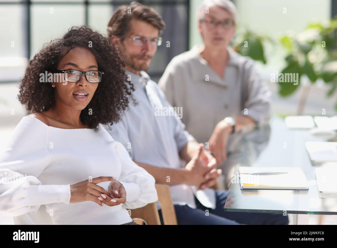 portrait of a young african american woman in the office at the table ...