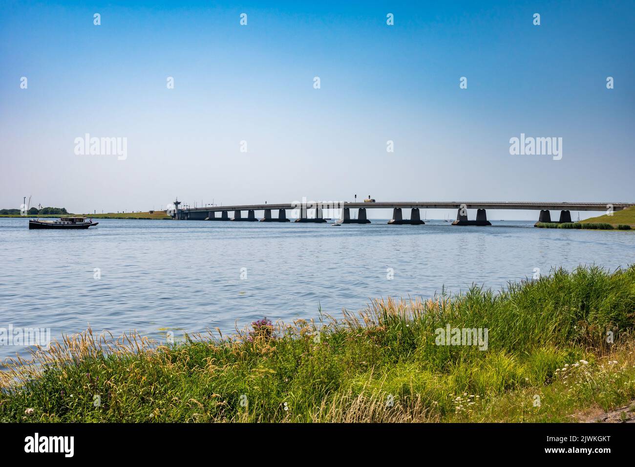 Nagele, Flevoland, The Netherlands - 07 20 2022 - Bridge over the Ketel lake with the green polder and ships Stock Photo