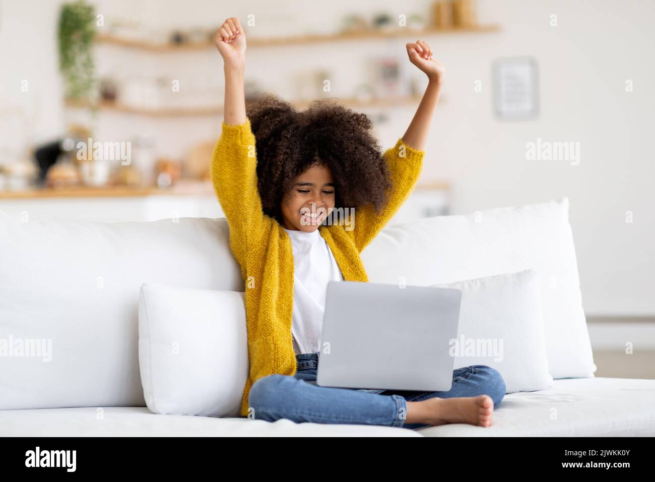 Happy african american child using laptop, raising hands up Stock Photo ...