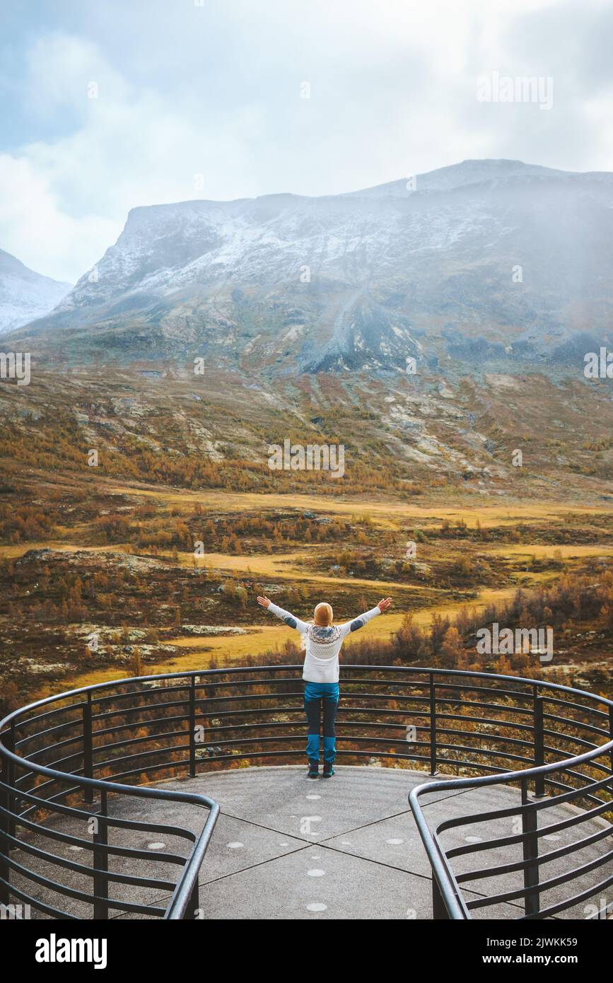 Woman exploring Norway travel outdoor autumn landscape tourist on Vegaskjelet viewpoint aerial view forest and mountains eco tourism Stock Photo