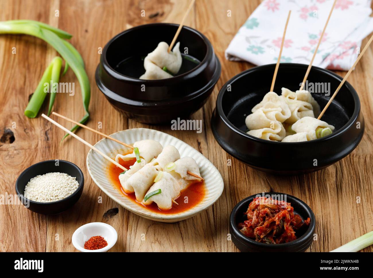 Odeng Guk with Various Broth, Spicy, Meat, and Chicken Broth. Served with Kimchi, Sesame Seed, and Gochugaru. On Wooden Table Stock Photo