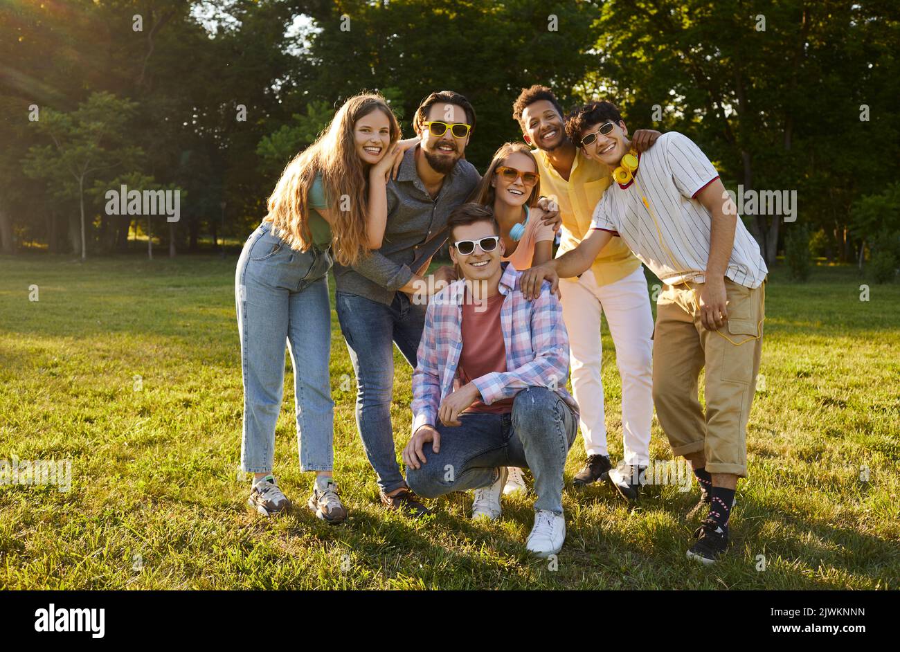 Young friendly multiethnic people in casual clothes posing with smile after summer walk together Stock Photo