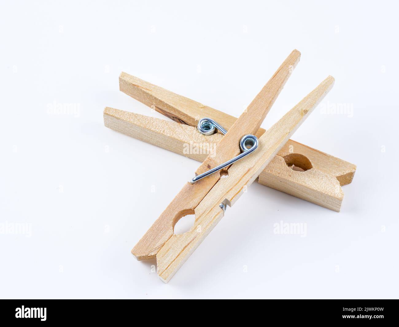 Stainless steel spring type wooden clothes pegs isolated on a white background Stock Photo